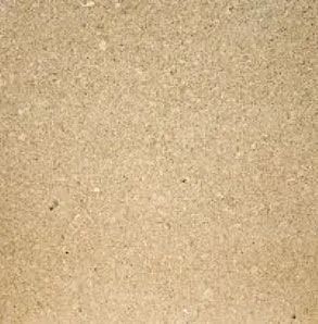 Tan, speckled surface of particle board.