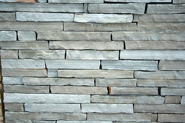Stacked rectangular stone wall in shades of gray.