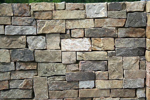 Stone wall with various colors and sizes of rectangular stones.