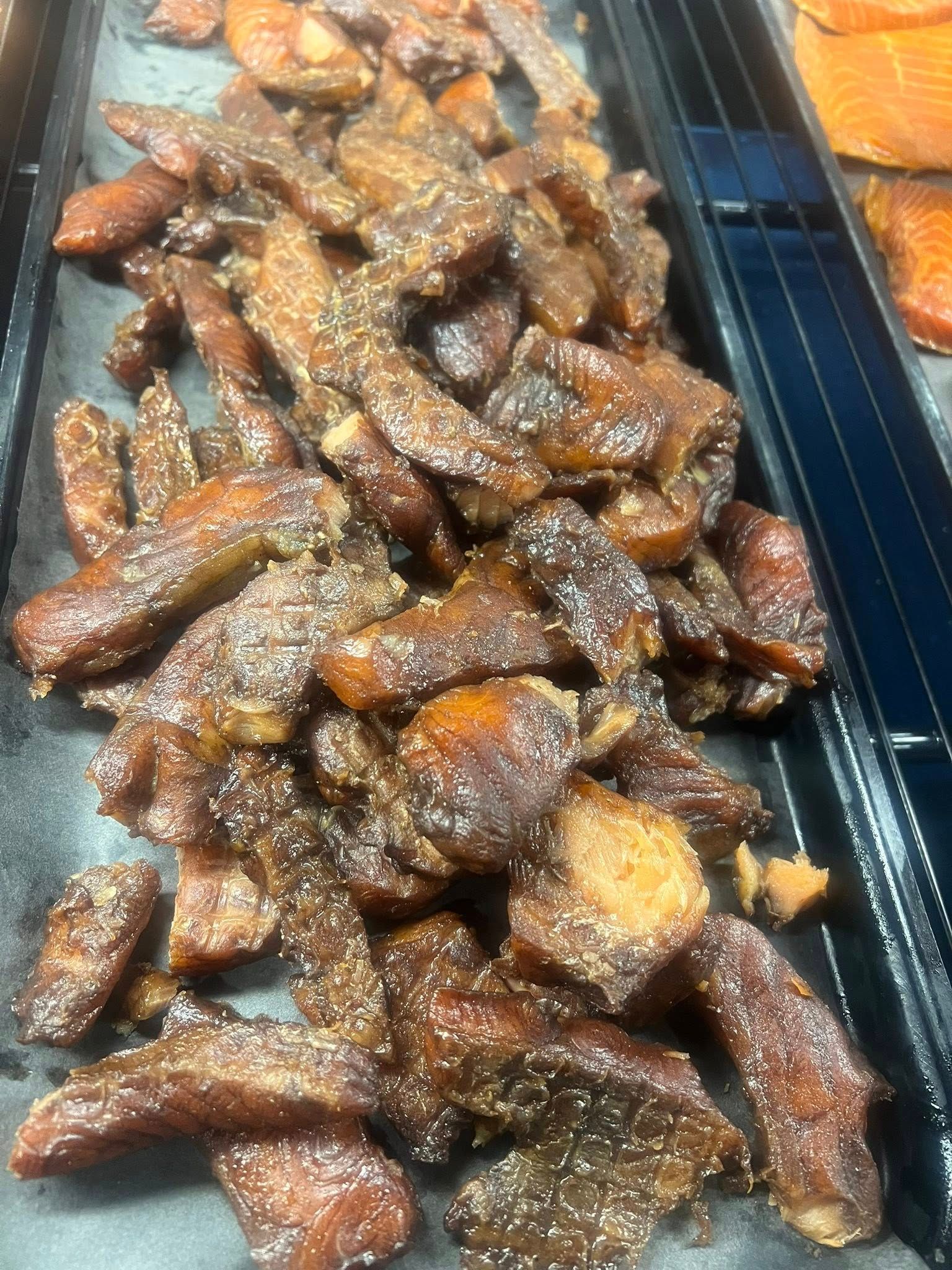 Pile of glazed, seasoned chicken wings in a display case.