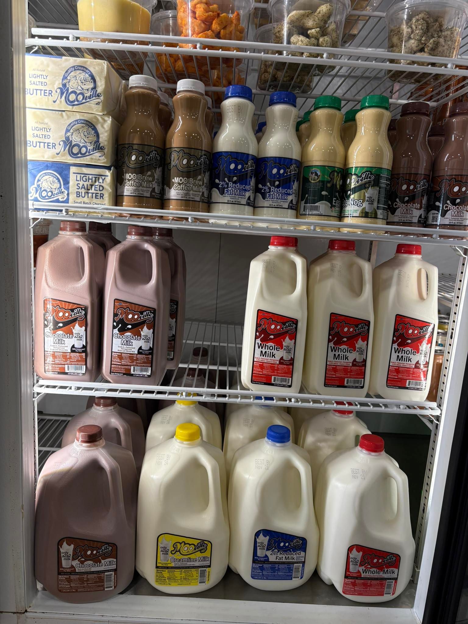 Refrigerator display: various milk bottles and jugs in different flavors, including chocolate, white, and other colors.