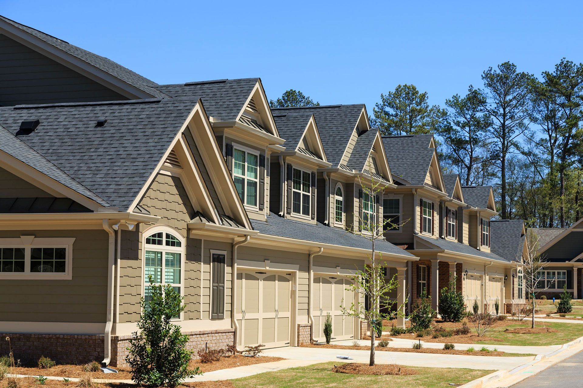 A row of houses with a blue sky in the background