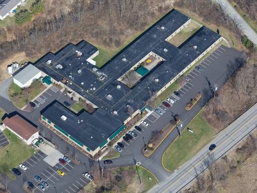 An aerial view of a large building with cars parked in front of it