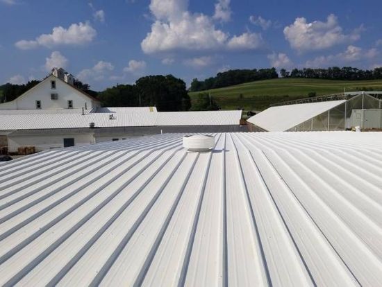 A white roof of a building with a blue sky in the background