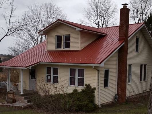 A white house with a red roof and a chimney