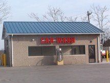 A car wash with a blue roof and a red sign