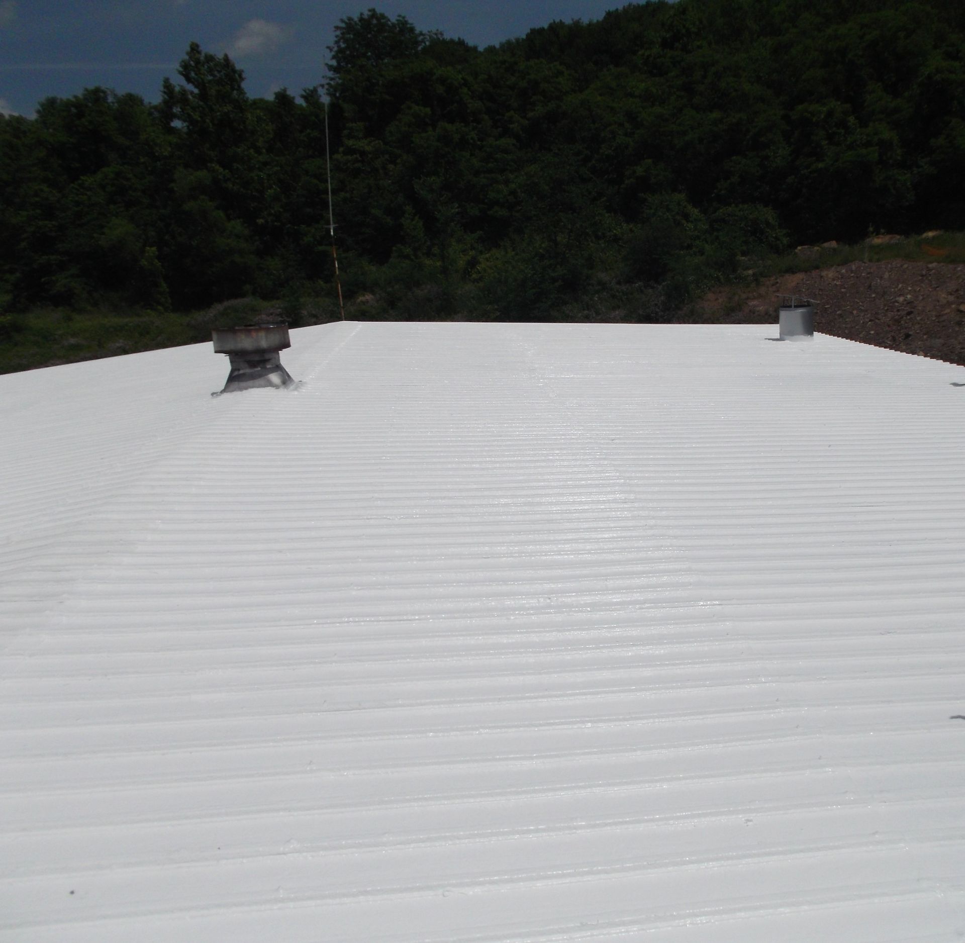 A white roof with a chimney on top of it