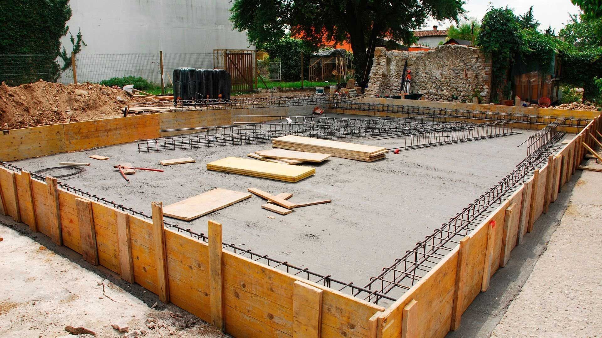 Wooden forms with wet concrete and rebar, site for a building's foundation.