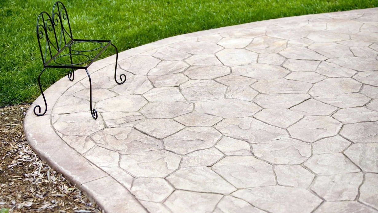Stone walkway with garden beds, illuminated by modern black bollard lights.