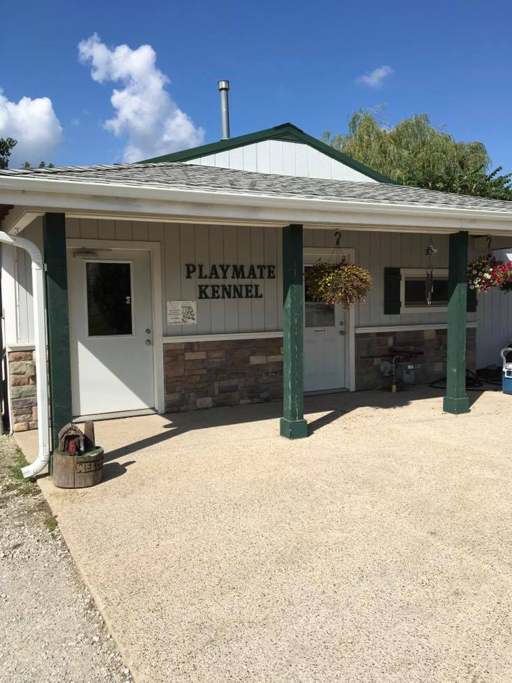A building with a sign that says playmate kennel on it