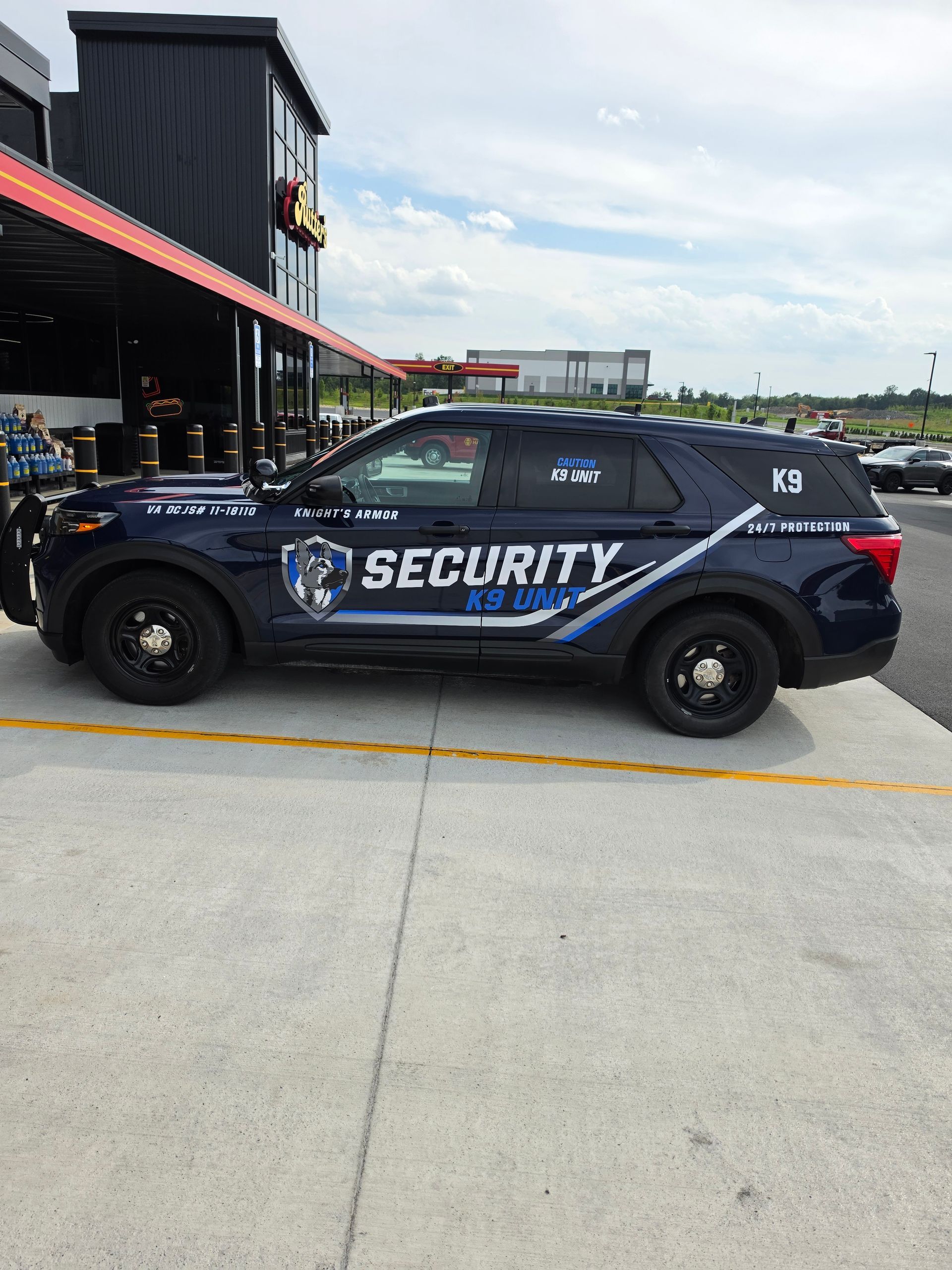 Black security SUV parked outside a building on a cloudy day.