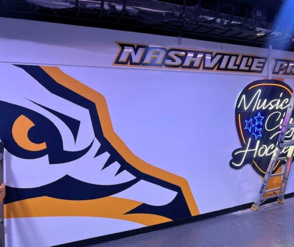 A wall mural featuring the Nashville Predators' saber-toothed tiger logo and a Music City Hockey neon-style sign.