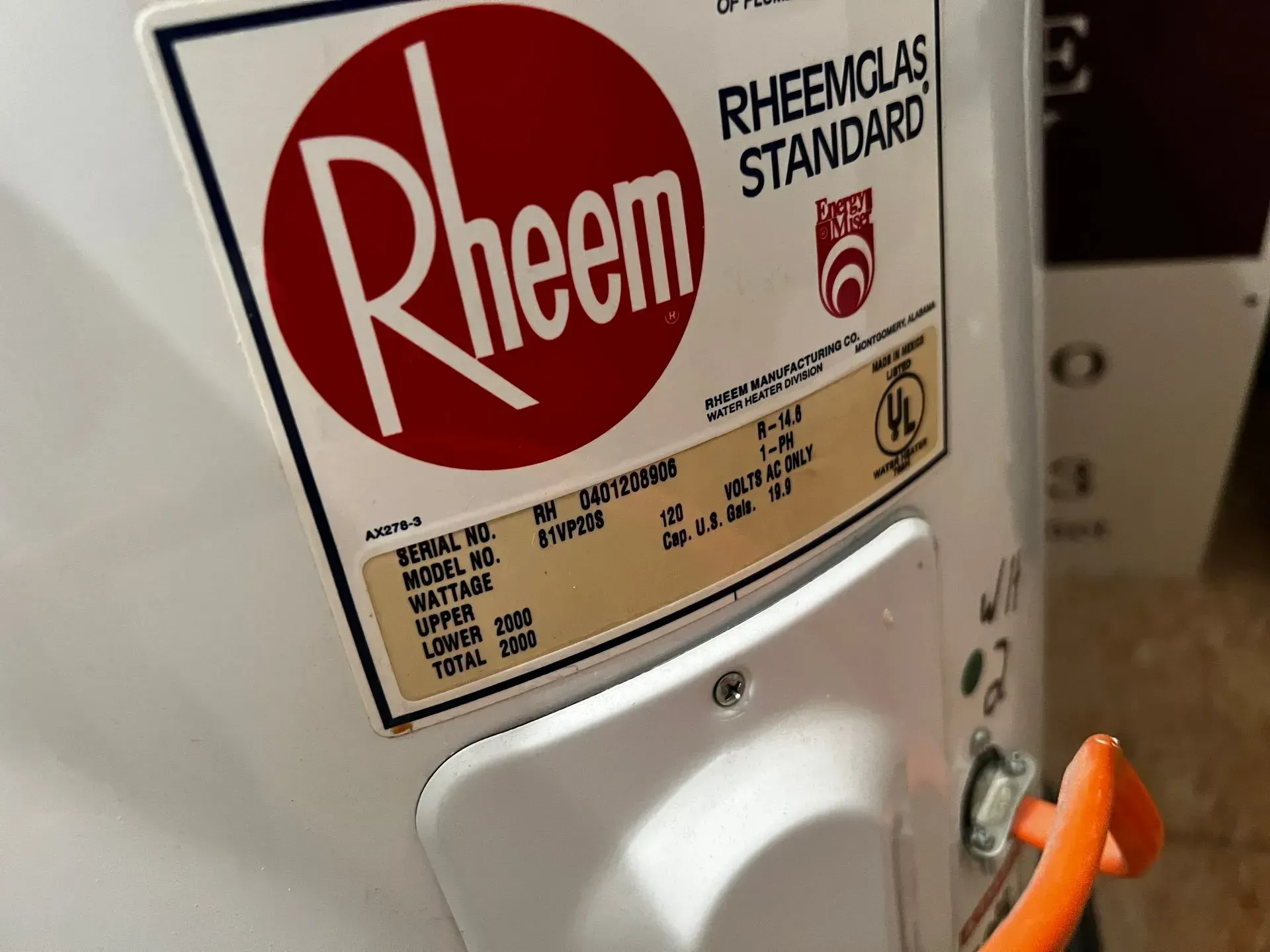 Close-up of a Rheem water heater with an orange valve handle and white label