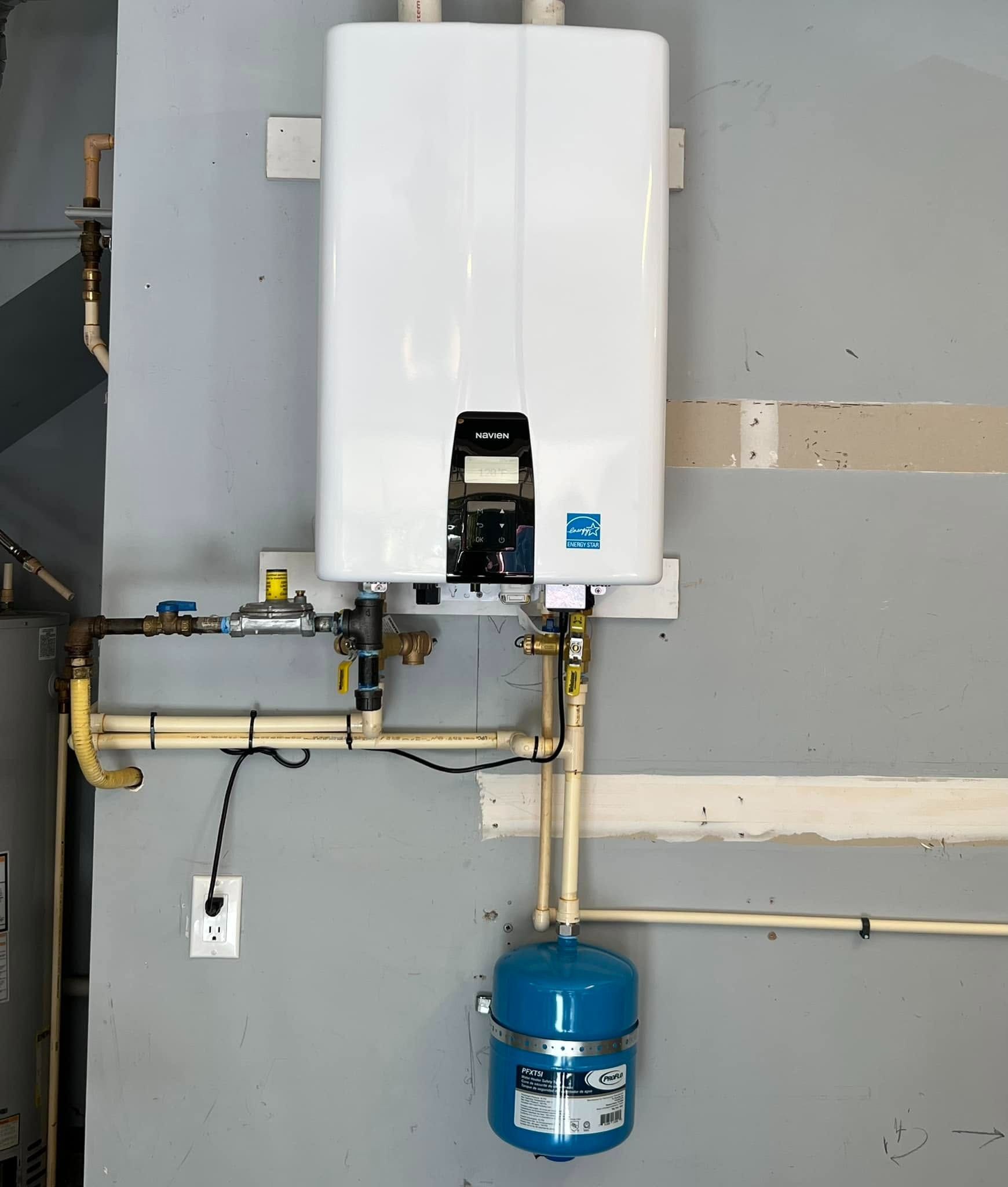 White wall-mounted water heater with blue expansion tank and exposed piping in a utility room