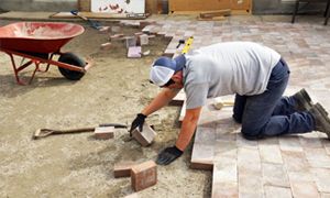 A man installing pavers for a patio