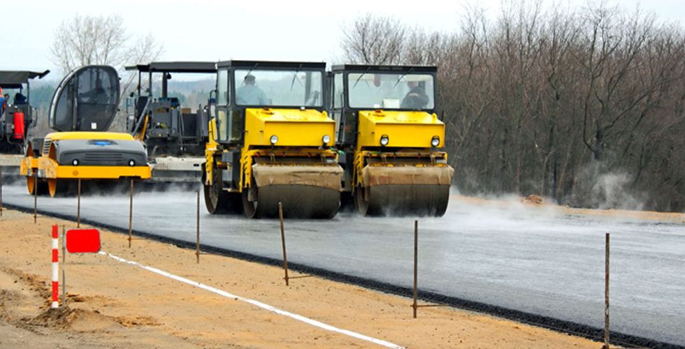 Several steam rollers flattening asphalt