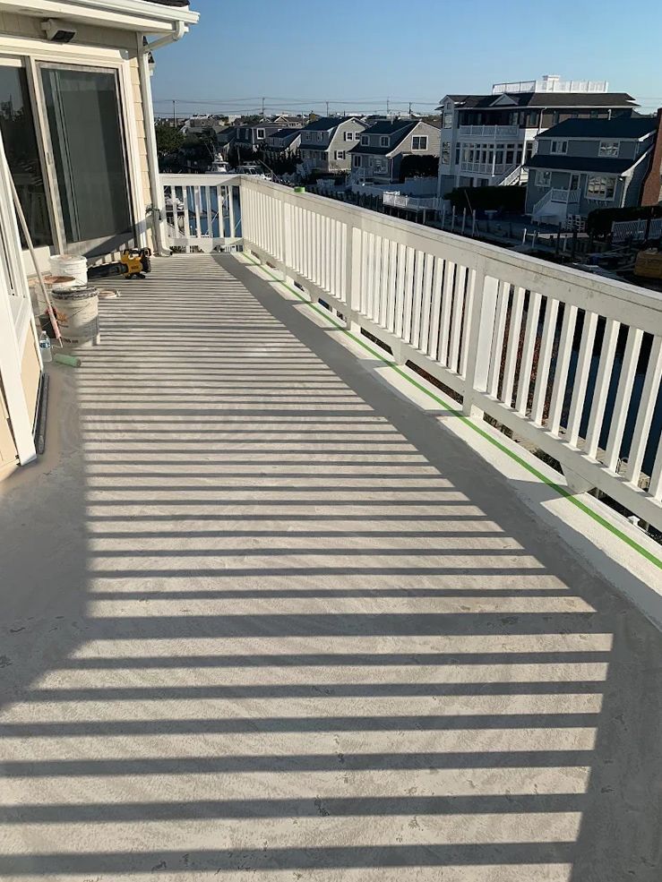 A balcony with a white railing and a view of a city.