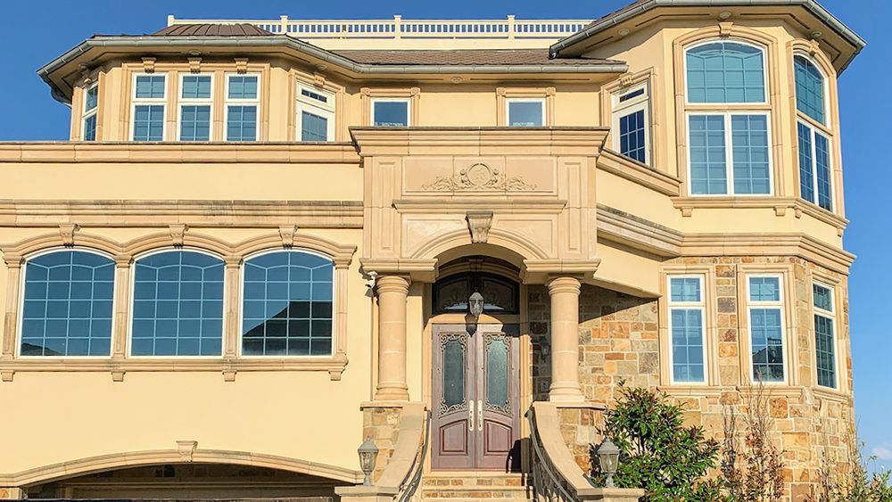 A large house with a lot of windows and a blue sky in the background.
