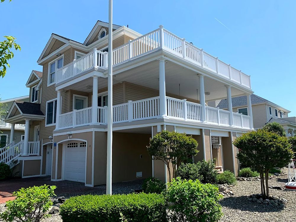 A large house with a large balcony and a flag pole in front of it.