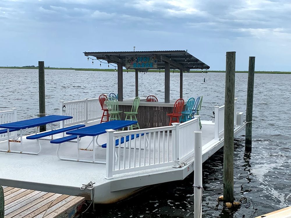 A dock with tables and chairs on it in the water