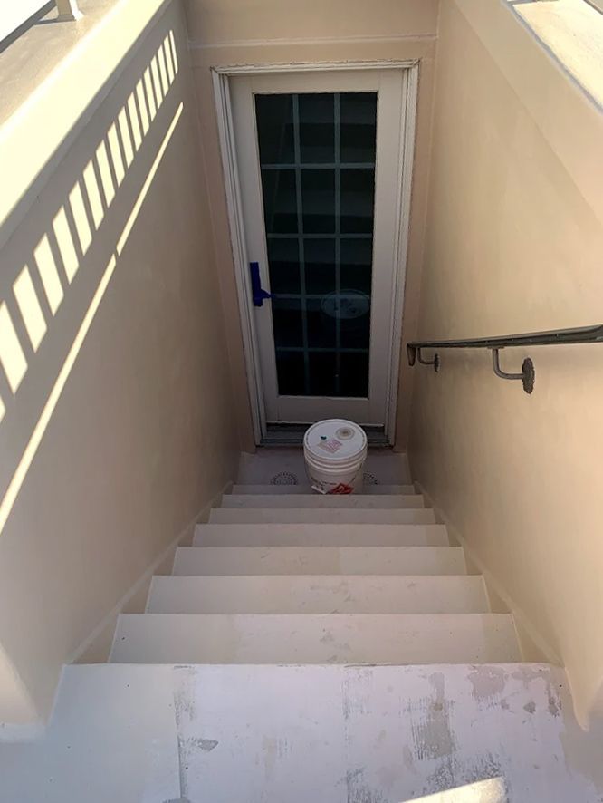 A set of stairs leading up to a door in a basement.