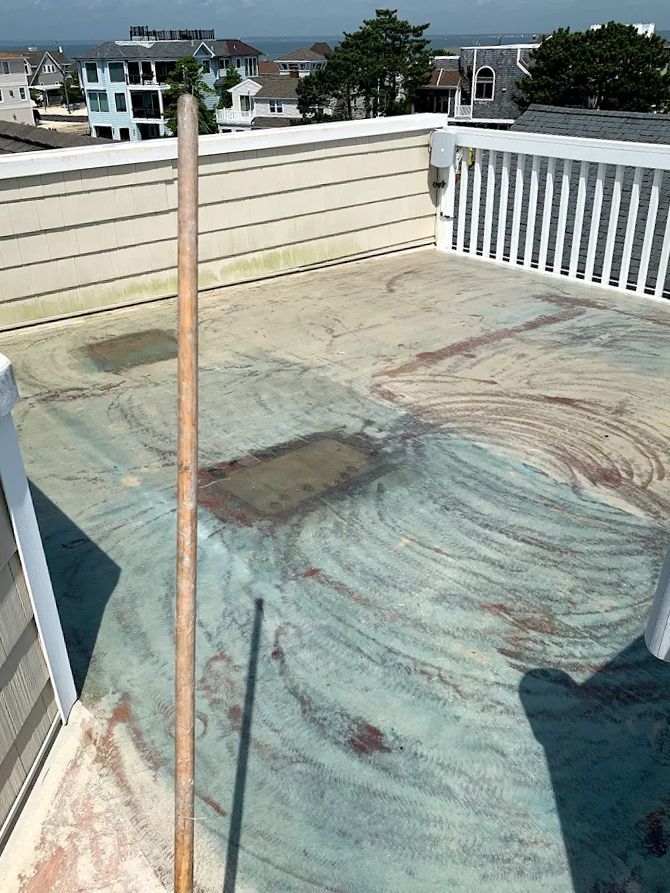 A wooden broom is sitting on top of a dirty roof.