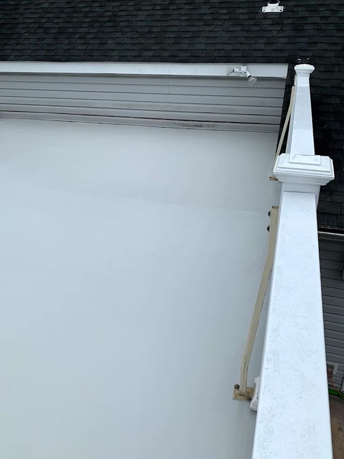 There is a white railing on the side of a building.