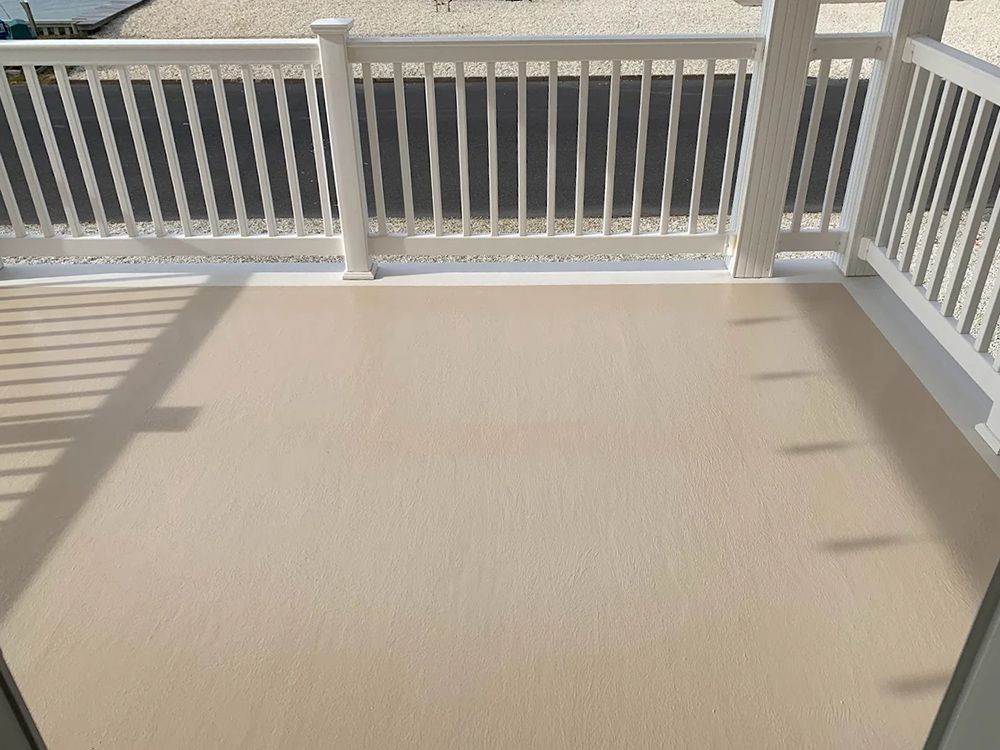 A balcony with a white railing and a beige floor.