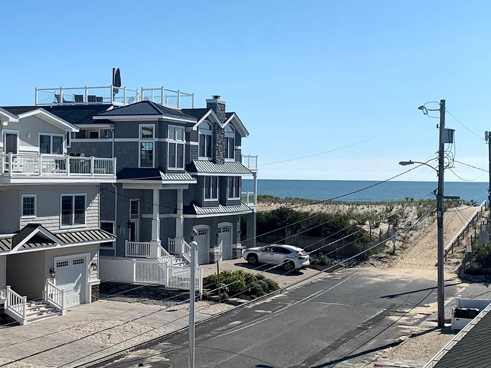 A row of houses on the beach with a view of the ocean.