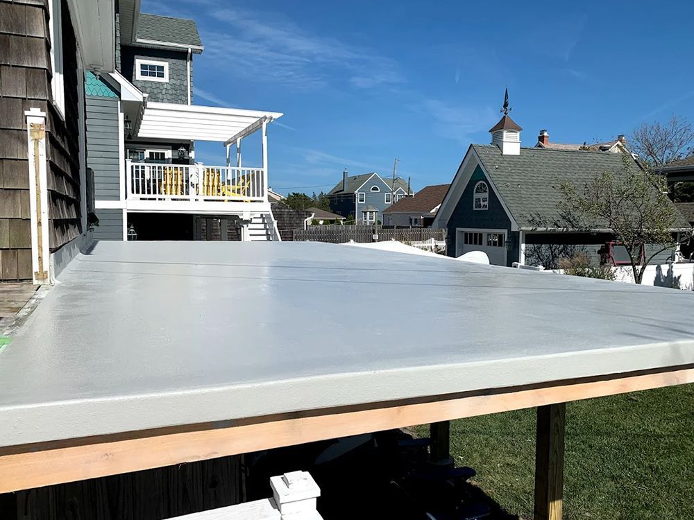 A white deck is sitting in front of a house.