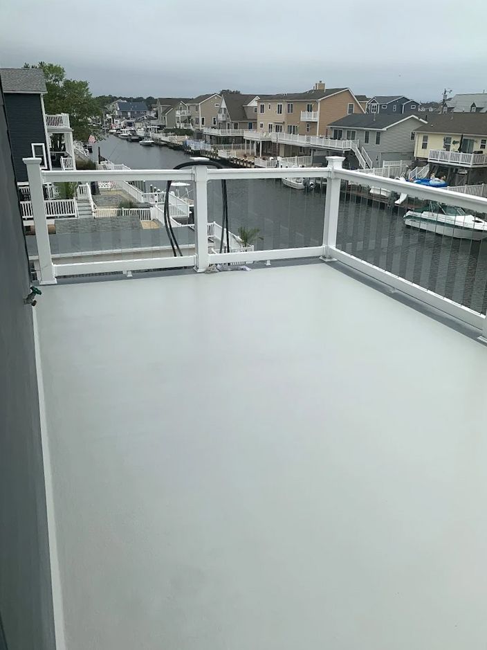 A balcony with a white railing overlooking a body of water.