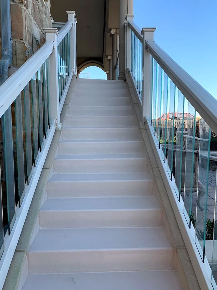 A set of stairs leading up to a balcony with a glass railing.