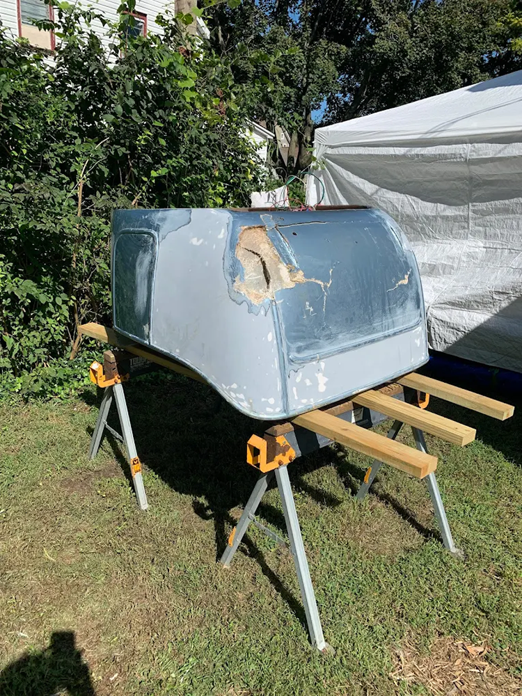A piece of metal is sitting on top of a wooden table in the grass.