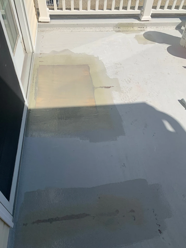 A balcony with a white railing and a shadow on the floor.