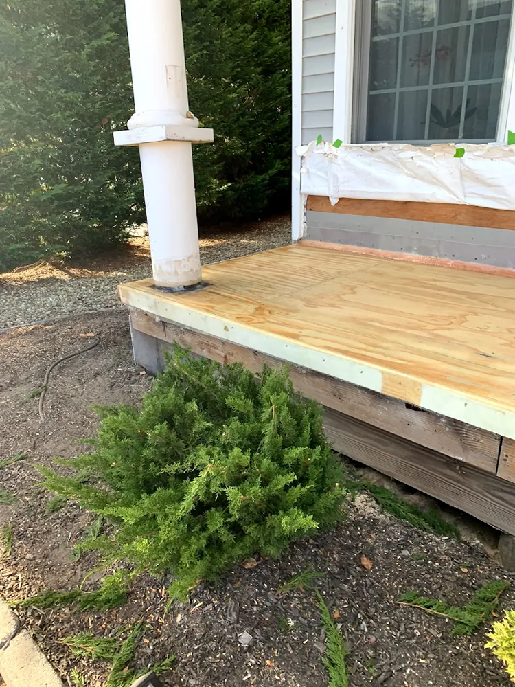 A wooden deck is being built on the side of a house.