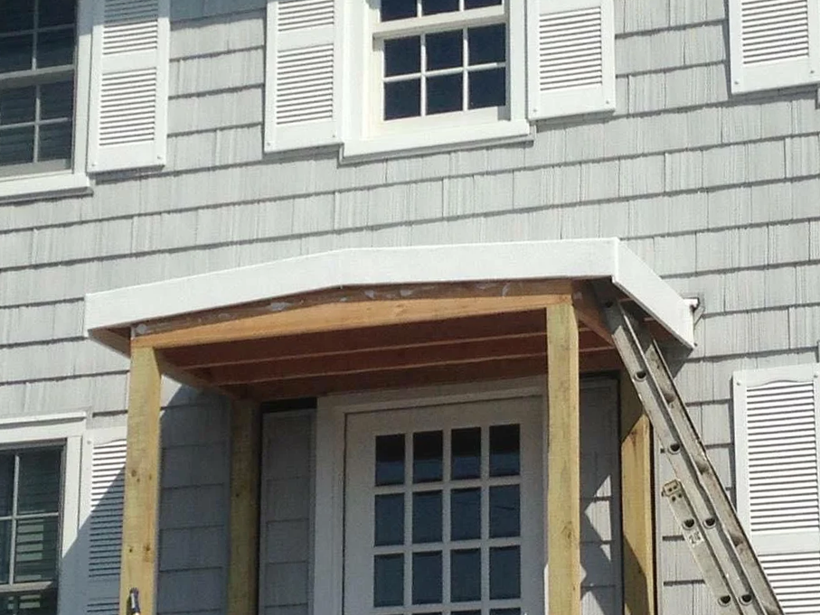 A house with a porch and a ladder in front of it