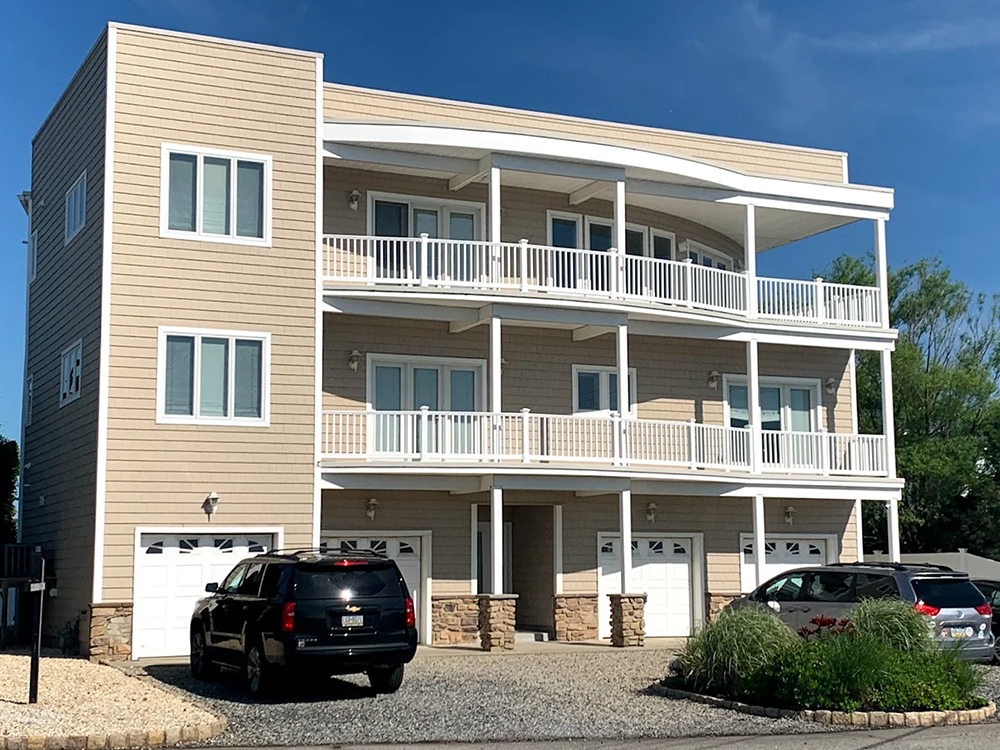 A large apartment building with cars parked in front of it
