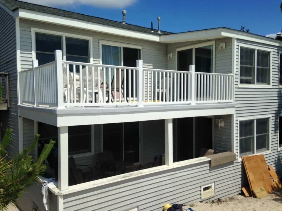 A house with a large deck and a white railing.