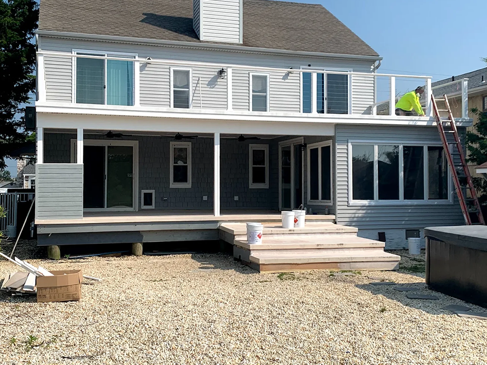 The back of a house with a large deck and stairs.