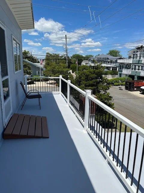 A balcony with a white railing and a chair on it