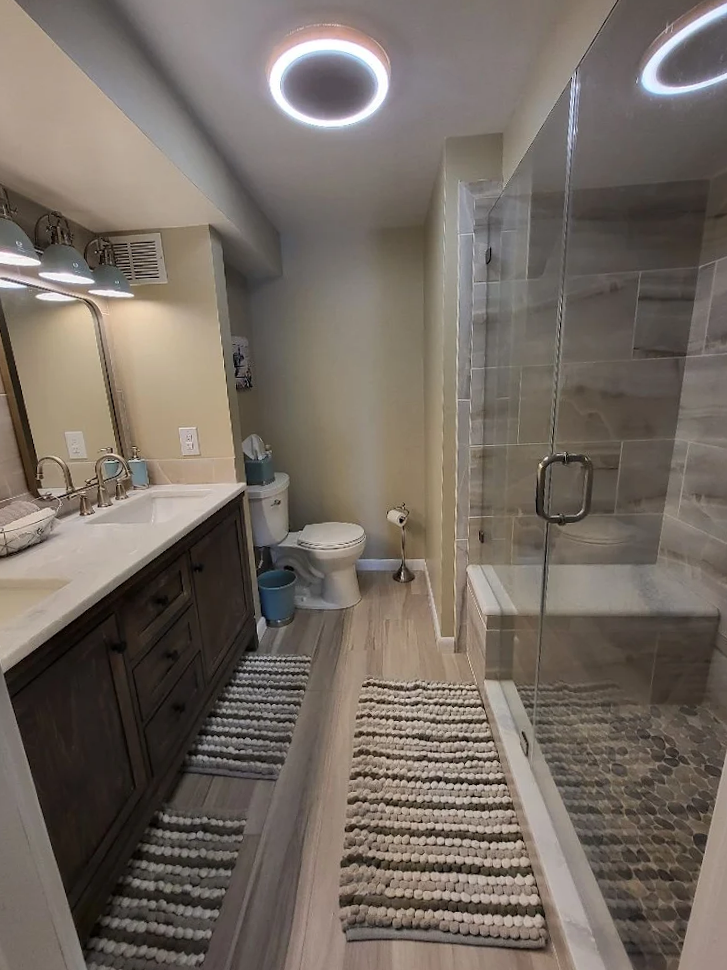 A bathroom with a toilet , sink , and shower.