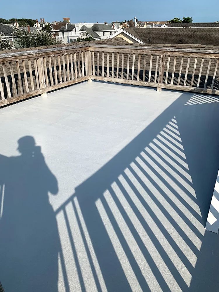 A shadow of a person is cast on a white deck