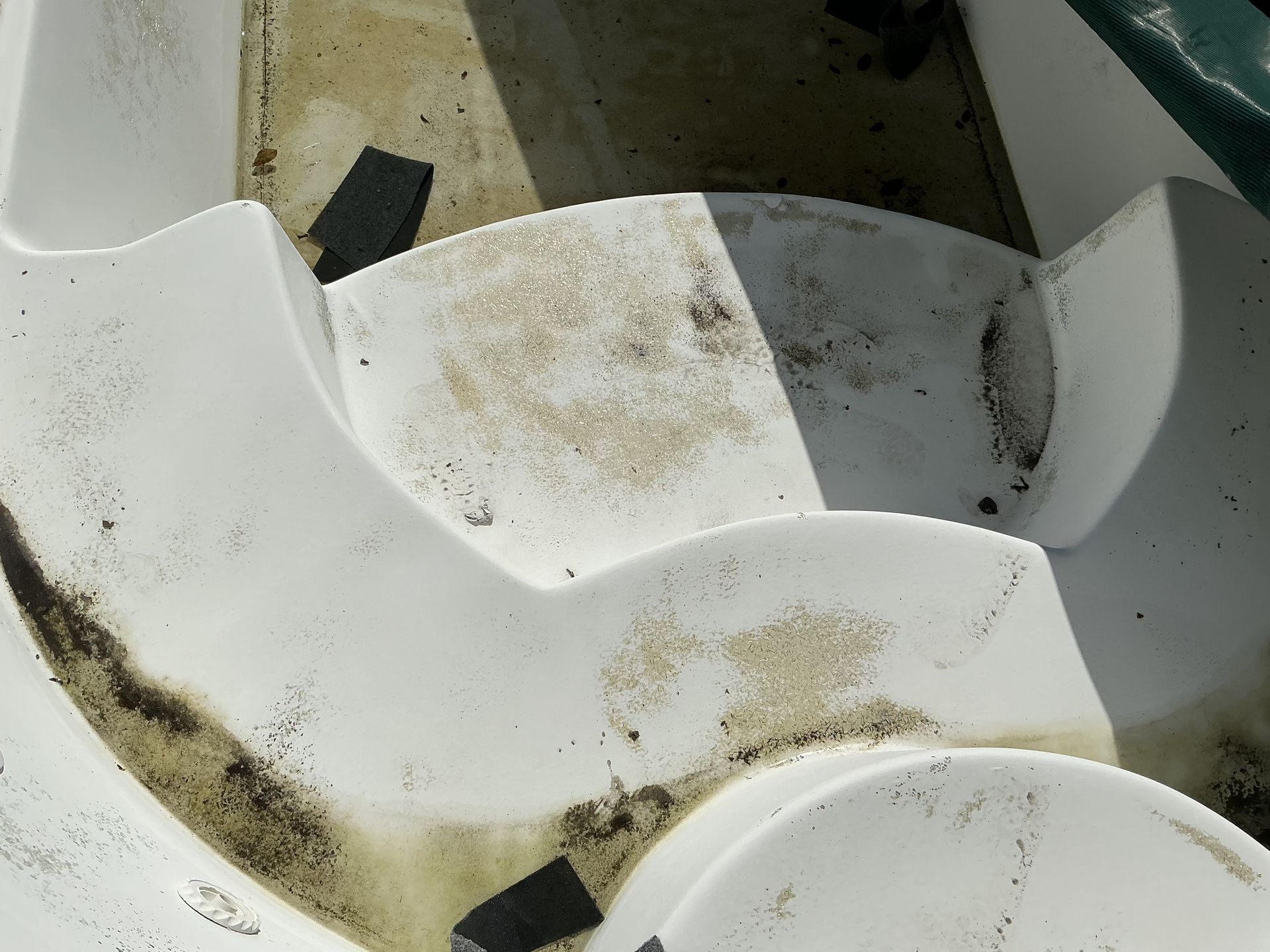 White plastic boat interior with dirt and debris.