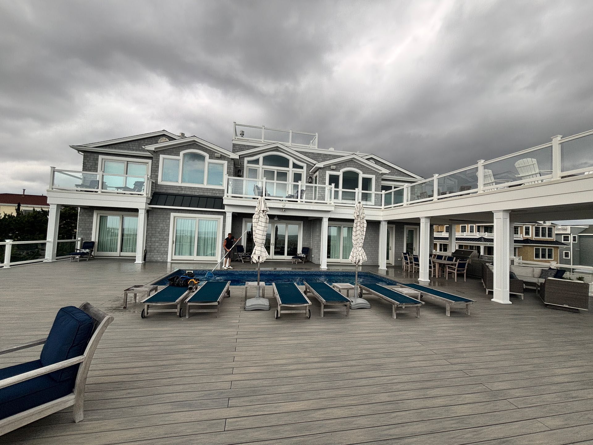 A large white house with a large swimming pool on the deck.