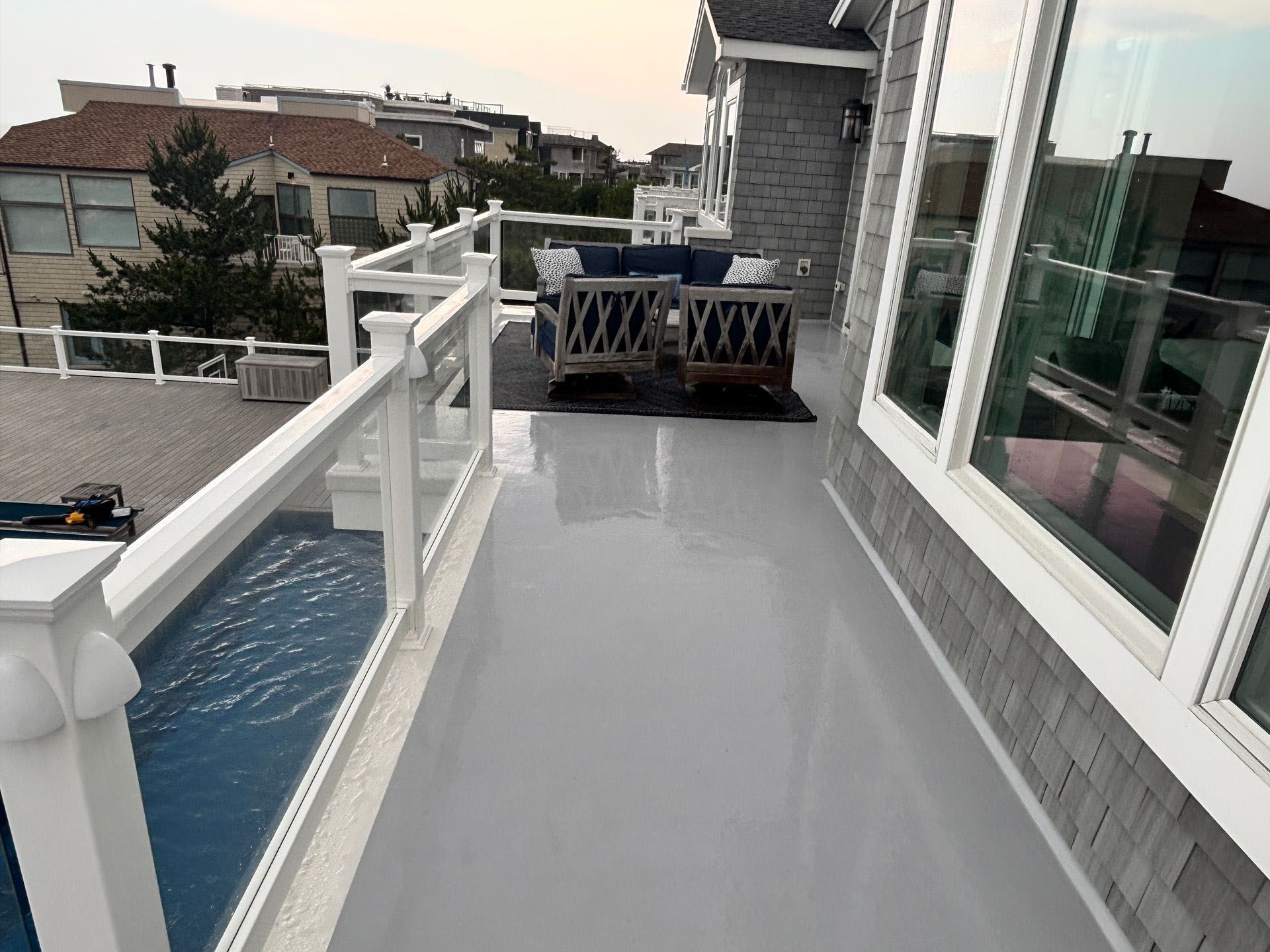 A balcony with a couch and chairs on it.