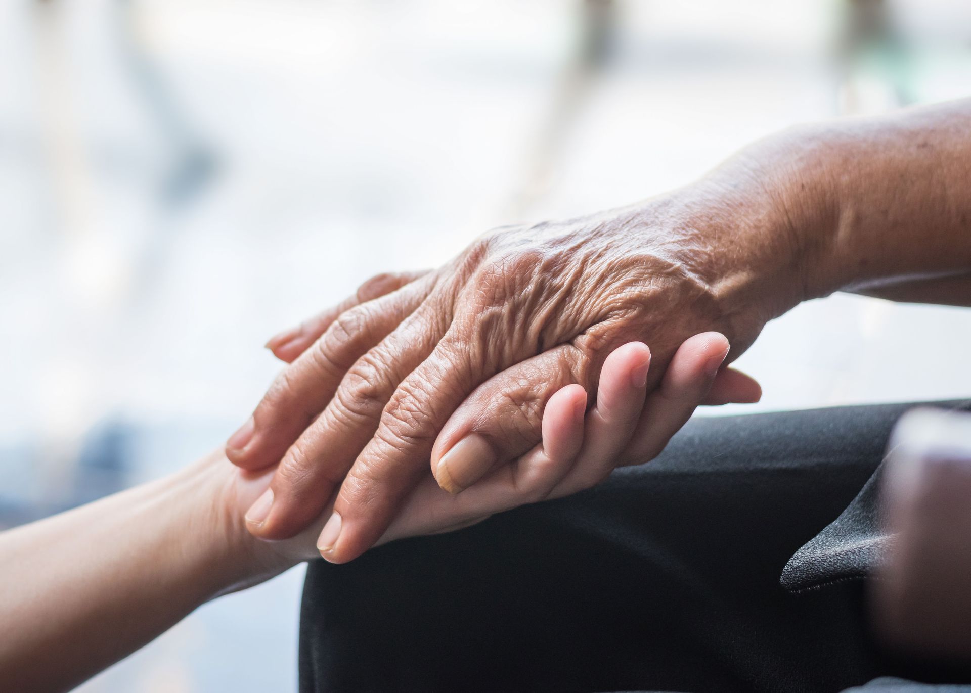 An elderly woman is holding a child 's hand.