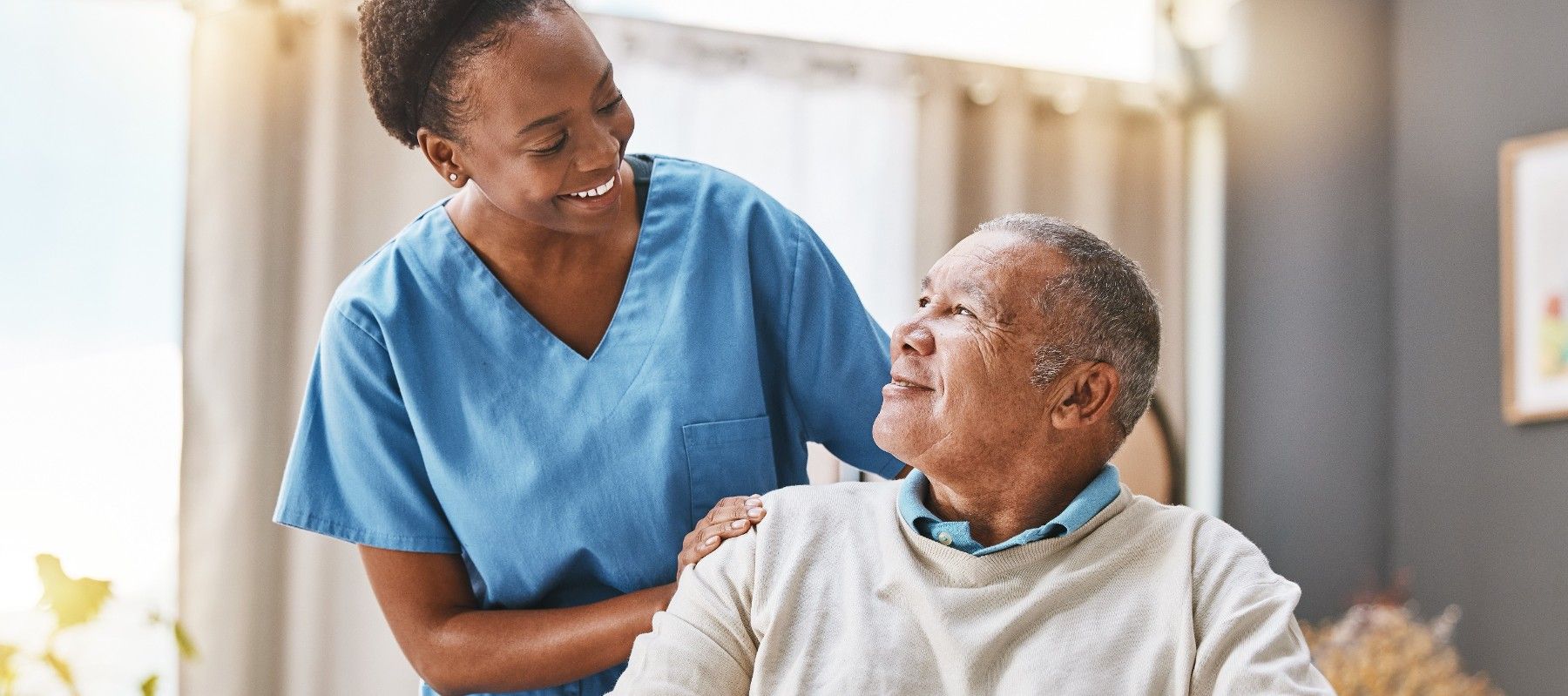 A nurse is helping an elderly man in a wheelchair.