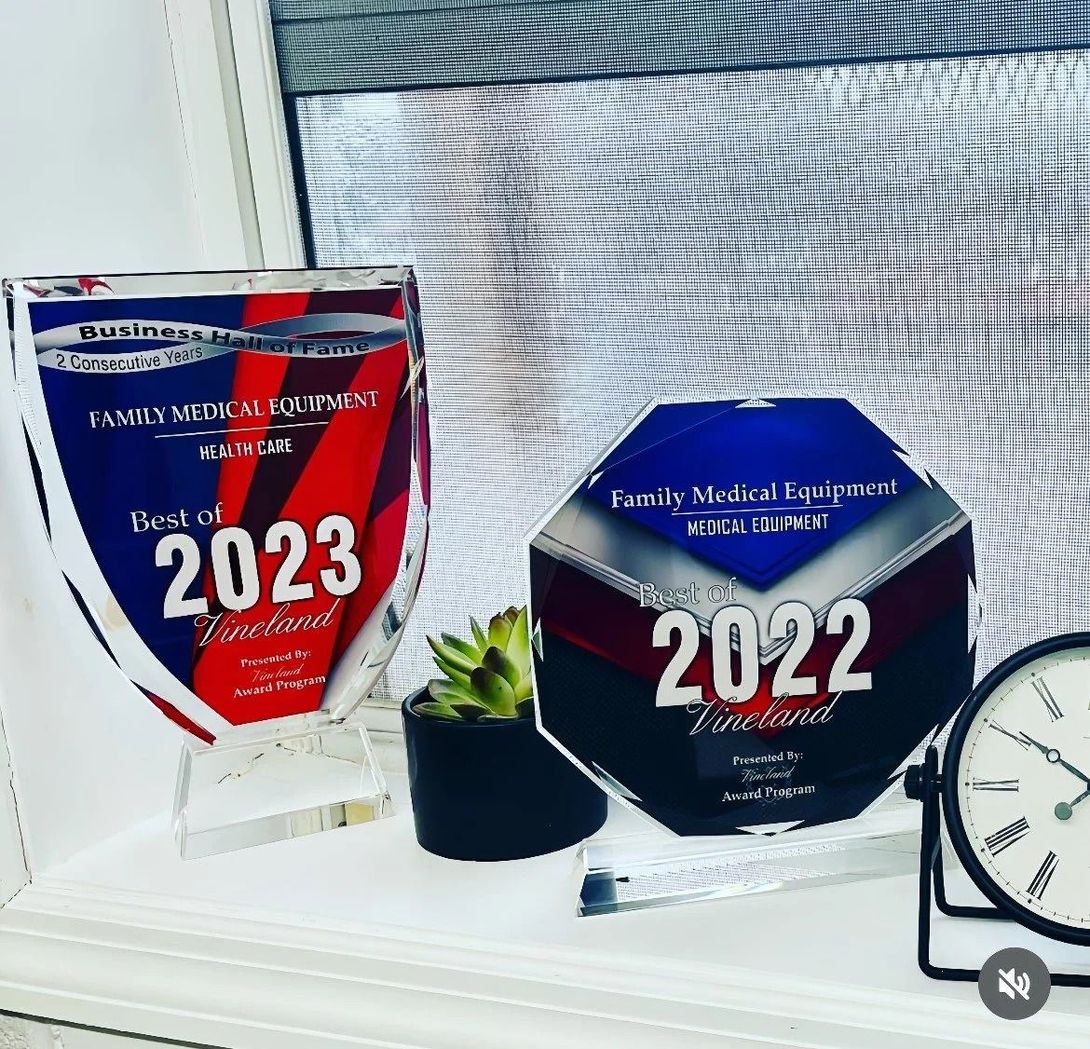 Two award plaques, "Best of 2023" and "Best of 2022," sit on a shelf. A small plant and clock are also visible.