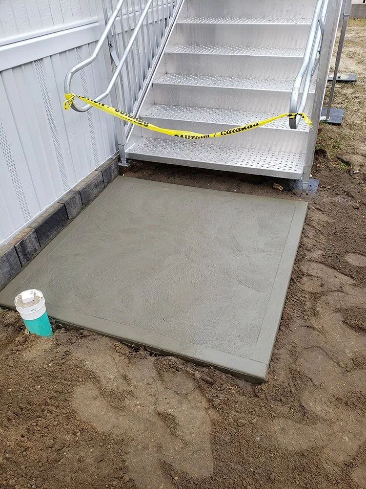 Concrete ramp to metal stairs beside a building, blocked by yellow caution tape.
