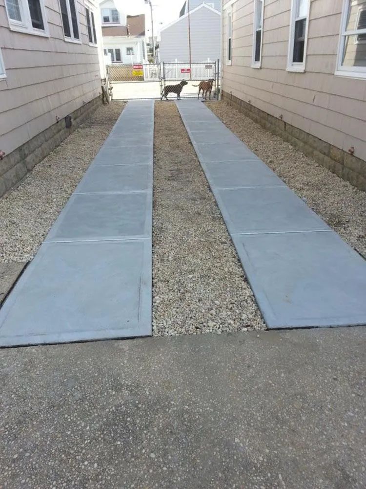 Two blue mats forming a walkway between houses over a gravel path.